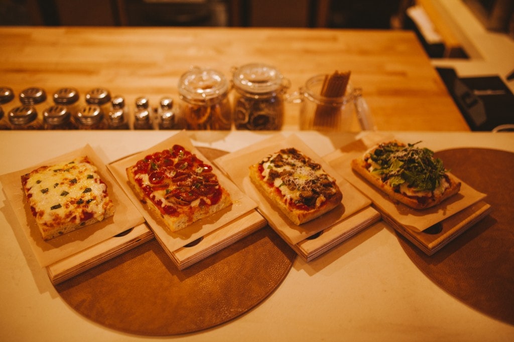 Four square pizza slices lined up on the bar at Analogue Room in Solvang