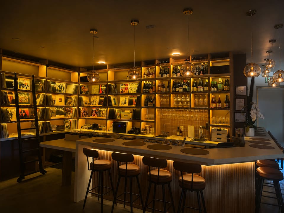 The Analogue Room bar in Solvang with vinyl shelves, wine bottles, and turntables under warm pendant lights